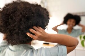 Jeune personne noire prenant soin de ses cheveux afro- Cheveux afro résultats réels avant après
